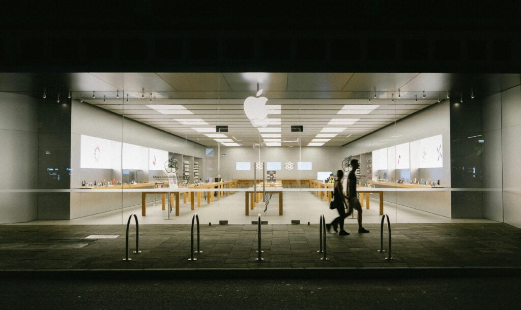 People Walking on the Sidewalk Near a Store with Glass Facade